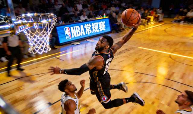 NBA 常规赛比赛现场，球员突破上篮的瞬间